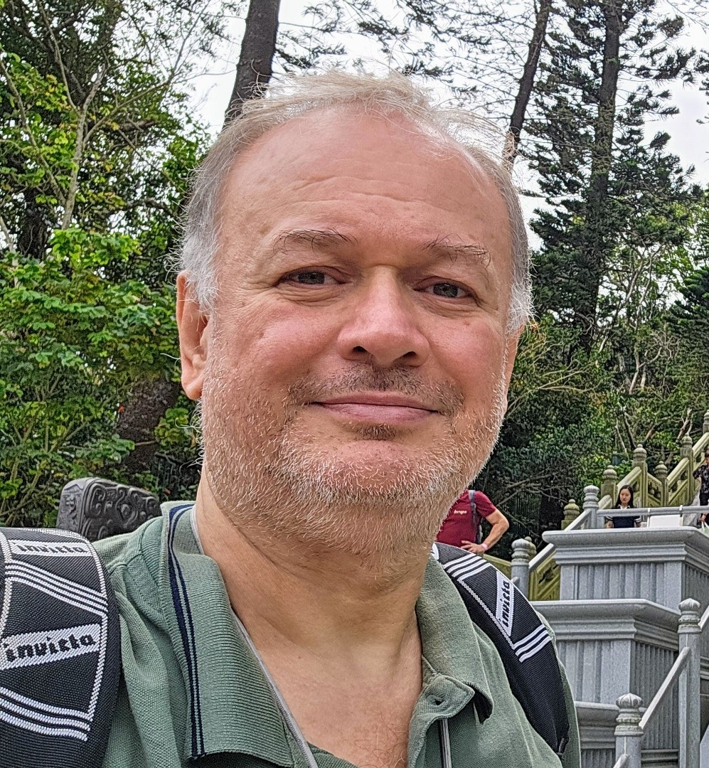 Ritratto di Roberto Spateri durante un viaggio in Asia, davanti a una grande scalinata monumentale.